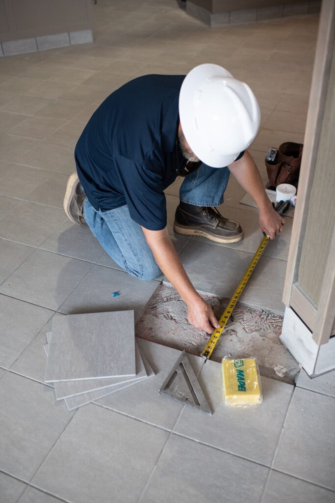 man repairing floor tile